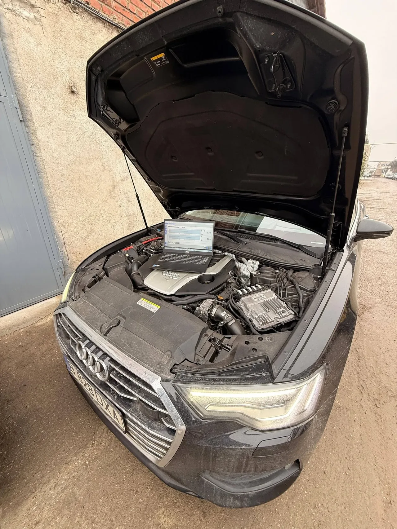 Audi cu capota deschisă și laptop de diagnoză